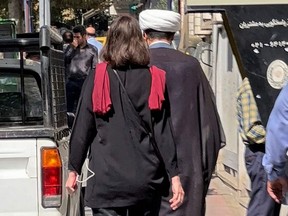 A picture obtained by AFP outside Iran shows a woman walking without a head scarf in the heart of the Iranian capital Tehran, Tuesday, Oct. 11, 2022.