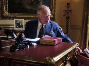 In this photo Sept. 11, 2022, taken Britain's King Charles III carries out official government duties from his red box in the Eighteenth Century Room at Buckingham Palace, London.