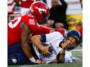 Toronto Argonauts quarterback McLeod Bethel-Thompson is sacked by Isaac Adeyemi-Berglund and Shawn Lemon of the Calgary Stampeders during CFL football in Calgary on Saturday, October 1, 2022. AL CHAREST / POSTMEDIA