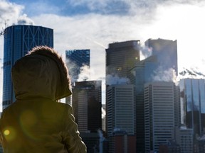 A woman takes in the Calgary skyline from Rotary Park on an extremely cold day on Jan. 4, 2022.