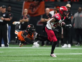 Calgary Stampeders' Malik Henry, right, gets past a diving B.C. Lions' T.J. Lee as he runs with the ball after making a reception during the second half of CFL football game in Vancouver, on Saturday, September 24, 2022.