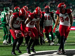 Calgary Stampeders running back Ka’Deem Carey (from left) and receivers Jalen Philpot and Reggie Begelton celebrate a touchdown against the Saskatchewan Roughriders 
at Mosaic Stadium in Regina on Saturday, Oct. 22, 2022.