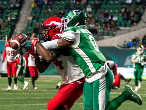 Saskatchewan Roughriders defensive back Rolan Milligan (0) knocks away an intended pass for Calgary Stampeders wide receiver Shawn Bane Jr. (14) during the first half of CFL football action in Regina on Saturday, October 22, 2022.