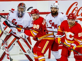 Calgary Flames forwards Andrew Mangiapane and Nazem Kadri fight for position against Carolina Hurricanes defenceman Brent Burns in front of goaltender Antti Raanta at Scotiabank Saddledome in Calgary on Saturday, Oct. 22, 2022.