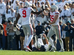Oct 29, 2022; University Park, Pennsylvania, USA; Ohio State Buckeyes defensive end Zach Harrison (9) and linebacker Tommy Eichenberg (35) celebrate following a tackle on Penn State Nittany Lions quarterback Sean Clifford (14) during the third quarter at Beaver Stadium. Ohio State defeated Penn State 44-31. Mandatory Credit: Matthew OHaren-USA TODAY Sports