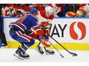 September 30, 2022; Edmonton, Alberta, Canada. Calgary Flames forward Conor Zary (47) looks to carry the puck around Edmonton Oilers defenseman Ryan Murray (28) in the second period at Rogers Place. Mandatory Credit: Perry Nelson-USA TODAY Sports