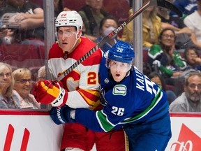 Calgary Flames defenceman Michael Stone battles Vancouver Canucks defenceman Wyatt Kalynuk during a pre-season game at Rogers Arena in Vancouver on Sept. 25, 2022.