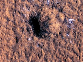 In this image made available by NASA on Thursday, Oct. 27, 2022, boulder-size blocks of water ice are seen around the rim of an impact crater on Mars, as viewed by the High-Resolution Imaging Science Experiment camera aboard NASA's Mars Reconnaissance Orbiter. The crater was formed Dec. 24, 2021, by a meteoroid strike in the Amazonis Planitia region.