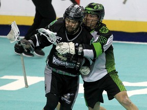 The Calgary Roughnecks’ Curtis Manning (left) and the Saskatchewan Rush’s Ryan Keenan fight for the ball during a game last season.