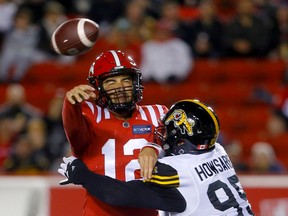 Calgary Stampeders quarterback Jake Maier battles Hamilton Tiger-Cats defensive lineman Julian Howsare at McMahon Stadium in Calgary on Friday, Oct. 14, 2022.