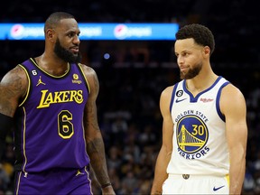 LeBron James of the Los Angeles Lakers speaks to Stephen Curry of the Golden State Warriors during their game at Chase Center on Oct. 18, 2022 in San Francisco, Calif.