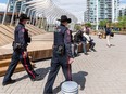 Calgary police officers approach a group of homeless people in East Village on Monday, May 30, 2022.