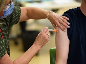 A registered nurse administers a flu shot at Richmond Road Diagnostic and Treatment Centre in Calgary on Oct. 17, 2022.