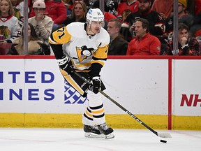 Evgeni Malkin #71 z Pittsburghu Penguins kontroluje puk v druhom polčase proti Chicagu Blackhawks 20. novembra 2022 v United Center v Chicagu, Illinois.  Malkin korčuľoval vo svojom 1000. zápase v NHL.