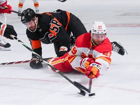 Calgary Flames forward Dillon Dube battles Philadelphia Flyers forward Tanner Laczynski at Wells Fargo Center in Philadelphia on Monday, Nov. 21, 2022.