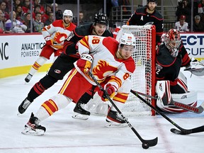 Andrew Manjapain #88 of the Calgary Flames moves the puck against Martin Nekas #88 of the Carolina Hurricanes during the second period of a game at PNC Arena in Raleigh, North Carolina on November 26, 2022.