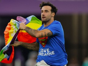 Mario Ferri, 35, who calls himself "The Falcon", and wearing a t-shirt reading "Save Ukraine" invades the pitch waving a rainbow-coloured Peace flag.