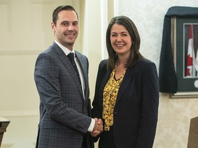 Matt Jones shakes hands with Alberta Premier Danielle Smith after Jones was sworn into cabinet as Minister of Affordability and Utilities in Edmonton, Monday, Oct. 24, 2022.