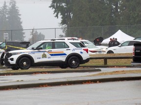 Police and a white tent erected in the parking lot at Tamanawis Secondary School in Surrey on Nov. 22, 2022.