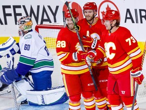 Calgary Flames forward Jonathan Huberdeau (second from right) celebrates a pre-season goal against the Vancouver Canucks with Elias Lindholm and Tyler Toffoli. The trio, who started the season skating together, have been reunited on the Flames’ first line.