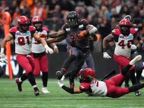 O running back do BC Lions, James Butler, ataca o defensive back do Calgary Stampeders, Branden Dozier, durante a semifinal da CFL West Division no BC Place, em Vancouver, no domingo, 6 de novembro de 2022.