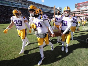 Nov 12, 2022; Fayetteville, Arkansas, USA; LSU Tigers players led by long snapper Slide Roy (44) and defensive end Lane Blue (42) carry The Boot trophy off the field after the game against the Arkansas Razorbacks at Donald W. Reynolds Razorback Stadium. LSU won 13-10. Mandatory Credit: Nelson Chenault-USA TODAY Sports