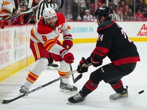 Le défenseur des Flames de Calgary Chris Tanev tire devant l'attaquant des Hurricanes de la Caroline Seth Jarvis au PNC Arena de Raleigh, en Caroline du Nord, le 26 novembre 2022.