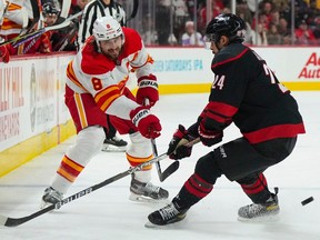 Calgary Flames defenceman Chris Tanev takes a shot past Carolina Hurricanes forward Seth Jarvis at PNC Arena in Raleigh, N.C., on Nov. 26, 2022.
