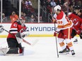 New Jersey Devils goaltender Vitek Vanecek makes a save in front of Calgary Flames forward Dillon Dube (29) and Devils defenceman Ryan Graves at Prudential Center in Newark, N.J., on Tuesday, Nov. 8, 2022.