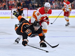 Philadelphia Flyers forward Kieffer Bellows dives past Calgary Flames defenseman Nikita Zadorov at the Wells Fargo Center in Philadelphia on Monday, November 21, 2022.