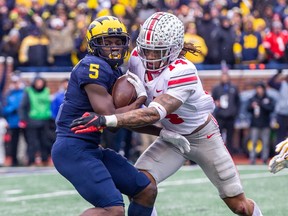 Michigan wide receiver Mike Sainristil (5) makes a 34-yard reception, defended by Ohio State safety Ronnie Hickman (14), in the third quarter of an NCAA college football game in Ann Arbor, Mich., Saturday, Nov. 27, 2021. Michigan plays Ohio State in Columbus, Ohio on Nov. 26, 2022.(AP Photo/Tony Ding, File)