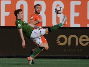 Cavalry defenseman Joel Waterman (left) taps the ball from Forge forward Anthony Novak during the Canadian Premier League final at Tim Hortons Field in Hamilton on October 26, 2019.  Forge won the two-match series 2-0.
