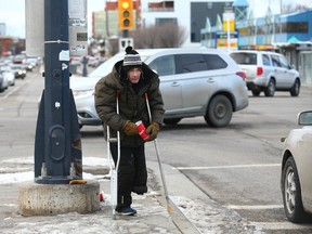 Parry Graham, 44 ans, se tient sur une médiane alors qu'il marche dans la circulation et récupère la monnaie à Edmonton Tr.  et 16 Ave. NE à Calgary le mercredi 16 novembre 2022.