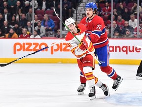 MONTREAL, CANADA - DECEMBER 12:  Arber Xhekaj #72 of the Montreal Canadiens holds back Matthew Phillips #41 of the Calgary Flames during the first period at Centre Bell on December 12, 2022 in Montreal, Quebec, Canada.