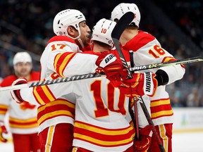 SEATTLE, WASHINGTON - DECEMBER 28: Jonathan Huberdeau #10 of the Calgary Flames celebrates his goal with Milan Lucic #17 and Nikita Zadorov #16 of the Calgary Flames during the third period against the Seattle Kraken at Climate Pledge Arena on December 28, 2022 in Seattle, Washington.