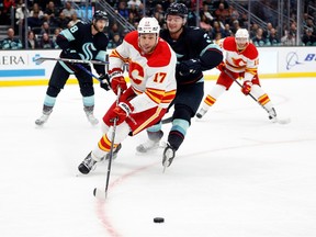 SEATTLE, WASHINGTON - DECEMBER 28: Milan Lucic #17 of the Calgary Flames handles the puck against Will Borgen #3 of the Seattle Kraken during the third period at Climate Pledge Arena on December 28, 2022 in Seattle, Washington.