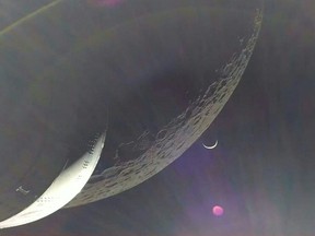 In this handout video grab courtesy of NASA TV the Earth is visible as a crescent in the minutes after Orion finished its engine burn around the moon on Dec. 5, 2022.