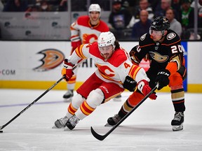 Calgary Flames defenceman Rasmus Andersson (4) moves the puck against Anaheim Ducks right wing Brett Leason (20) during the third period at the Honda Center on Dec 23, 2022 in Anaheim, California, USA.