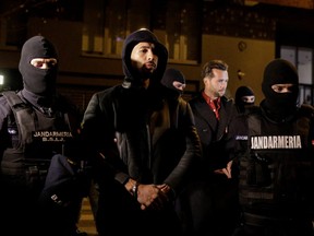 Andrew Tate and Tristan Tate are escorted by police officers outside the headquarters of the Directorate for Investigating Organized Crime and Terrorism in Bucharest (DIICOT) after being detained for 24 hours, in Bucharest, Romania, December 29, 2022.