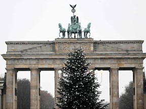 A Christmas tree with its top chopped off is seen in front of Berlin's landmark the Brandenburg Gate on Dec. 21, 2022.