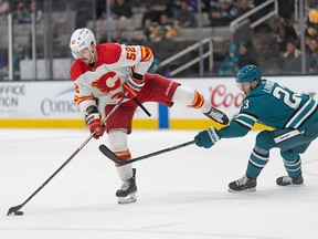 Calgary Flames defenseman MacKenzie Weegar shoots the puck past San Jose Sharks left wing Oskar Lindblom.