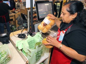 Mayuri Parikh, cashier with Calgary Co-op, is seen bagging groceries in biodegradable bags at a store checkout in October 2019.