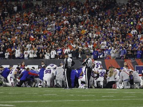 Buffalo Bills players huddle and pray after teammate Damar Hamlin #3 was injured against the Cincinnati Bengals during the first quarter at Paycor Stadium on January 2, 2023 in Cincinnati, Ohio.