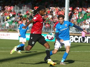 Cavalry FC’s Ali Musse gets a foot on a cross in front of Atletico Ottawa’s Maxim Tissot on ATCO Field at Spruce Meadows on Sept. 24, 2022.