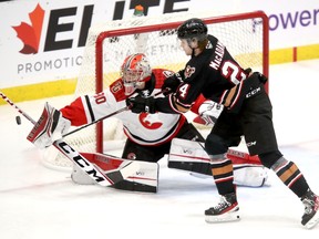 Calgary Hitmen forward Carter MacAdams chases the puck as Prince George Cougars goaltender Tyler Brennan defends at 7  Chiefs Sportsplex on Tsuut’ina Nation on Wednesday, Jan. 18, 2023.