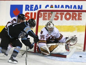 Calgary Hitmen goaltender Brayden Peters fends off an attempt by Winnipeg ICE forward Ty Nash at Scotiabank Saddledome in Calgary on Sunday, Jan. 29, 2023.