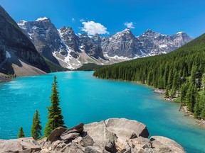 Turquoise waters of the Moraine lake with snow-covered peaks above it in Banff National Park.