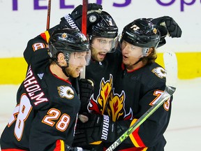 Flames defenceman Connor Mackey, centre, celebrates a goal with Elias Lindholm and Tyler Toffoli during a game against the St. Louis Blues on Dec. 16.