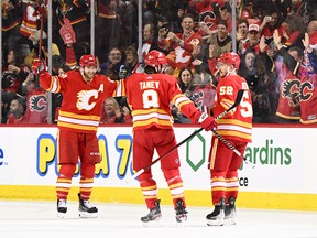 Calgary Flames defenceman MacKenzie Weegar (52) celebrates with teammates after scoring a goal against the Vancouver Canucks in the second period at the Scotiabank Saddledome in Calgary on Dec. 31, 2022.