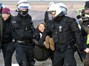 Police officers carry Swedish climate activist Greta Thunberg away from the edge of the Garzweiler II opencast lignite mine during a protest action by climate activists, in Luetzerath, Germany, Tuesday, Jan. 17, 2023.